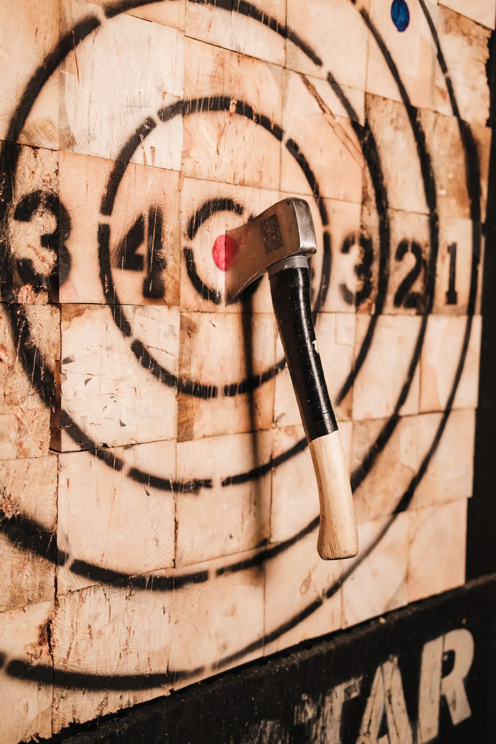 An axe embedded in a wooden throwing target